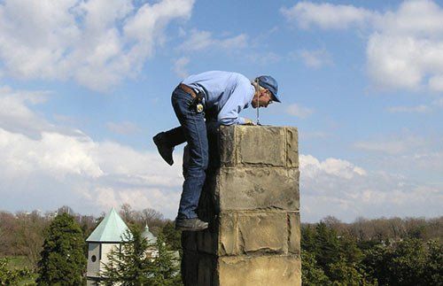 Worker inspecting inside of chimney -chimney relining in Ruther Glen, VA