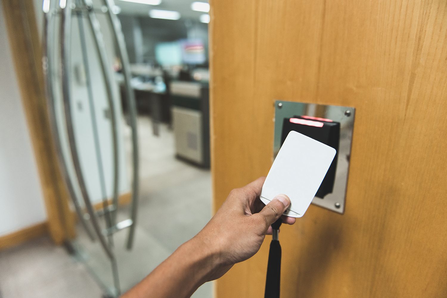 Employee using a key card for secure entry into an office room.