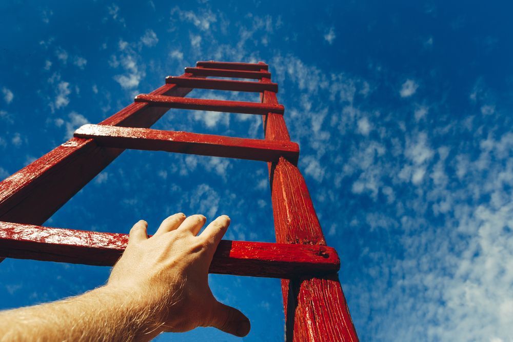 Hand Of Man Reaching For Red Ladder — Restorative Natural Therapies in Kincumber, NSW