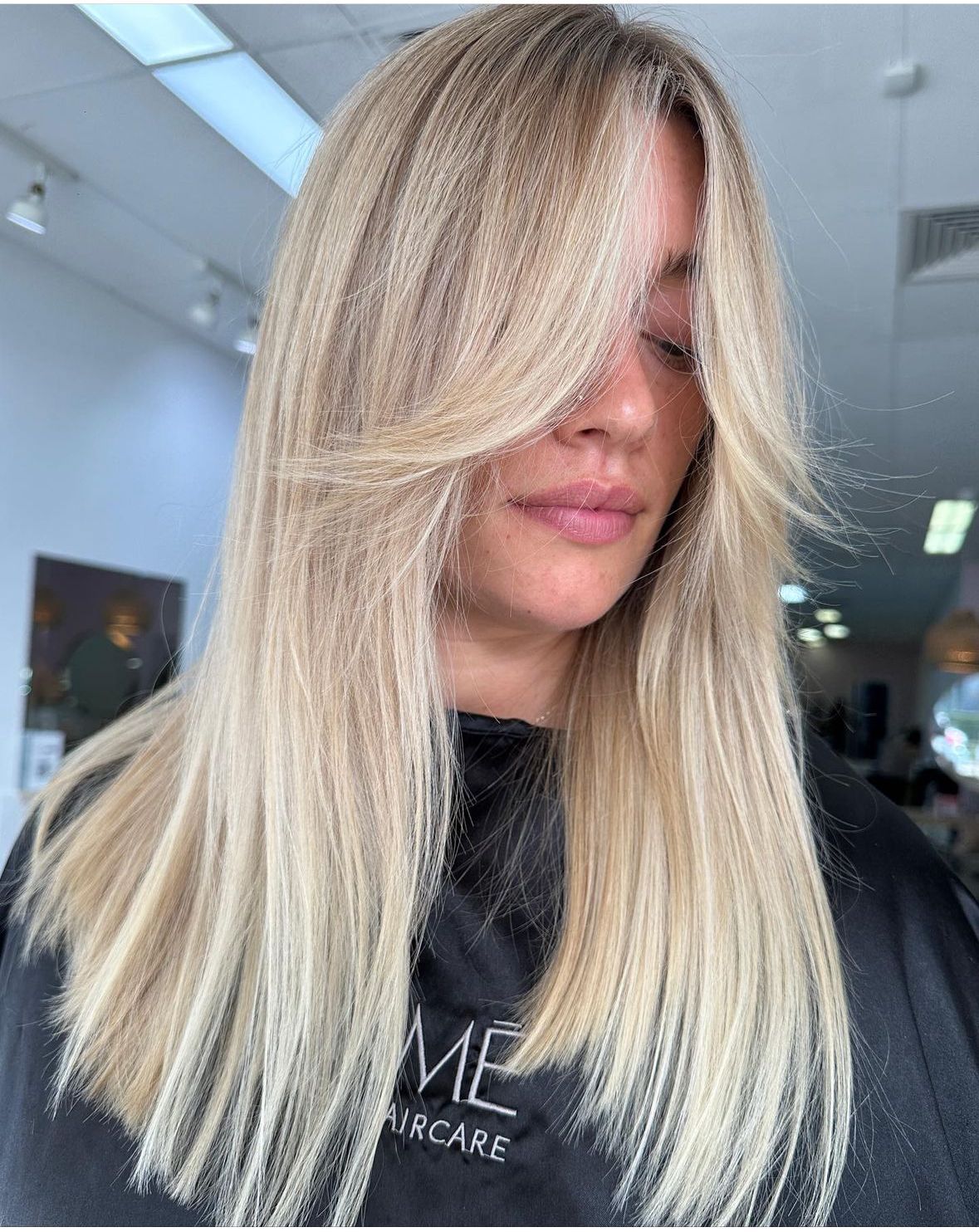A woman with long hair is wearing a white crop top.
