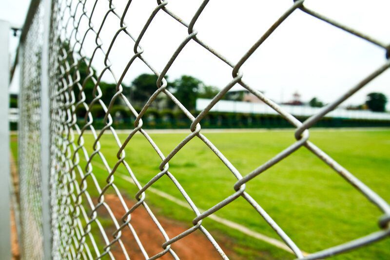 chain link fence around the park baseball field