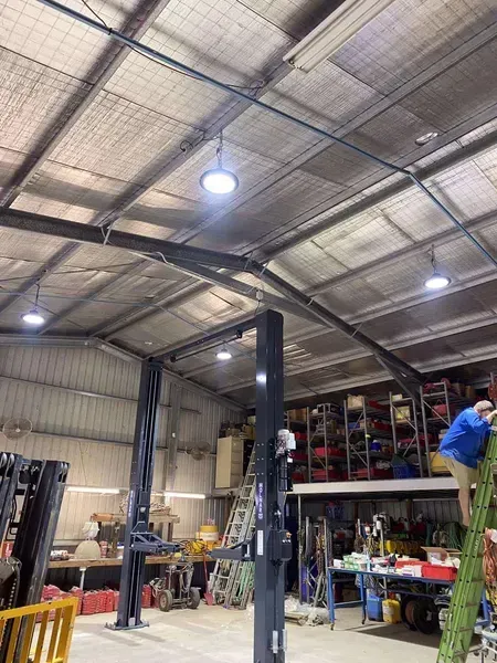 Interior of a Workshop With Car Lifts, Bright Overhead Lights — Lahtinen Electrical & Refrigeration in Ingham, QLD