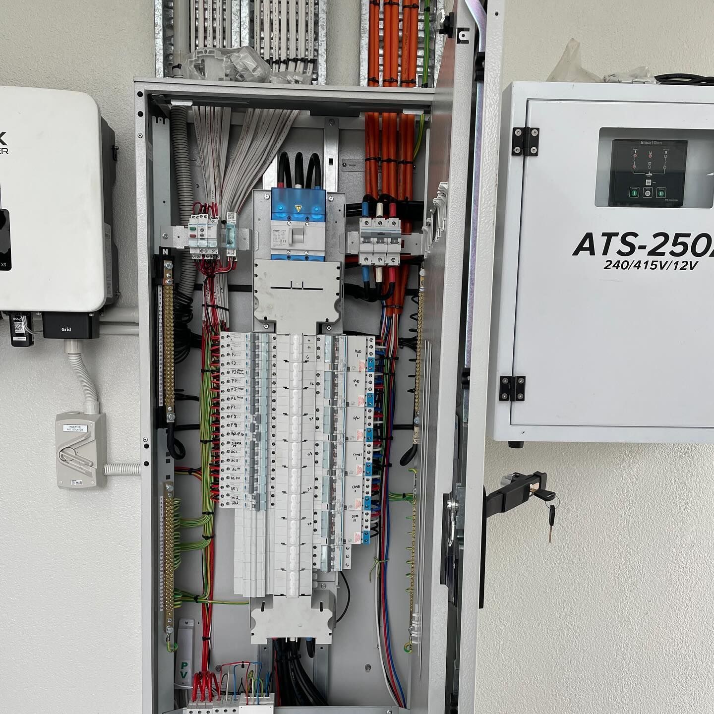 Electrical panel with wires and circuit breakers; adjacent white boxes.— Lahtinen Electrical & Refrigeration in Ingham, QLD