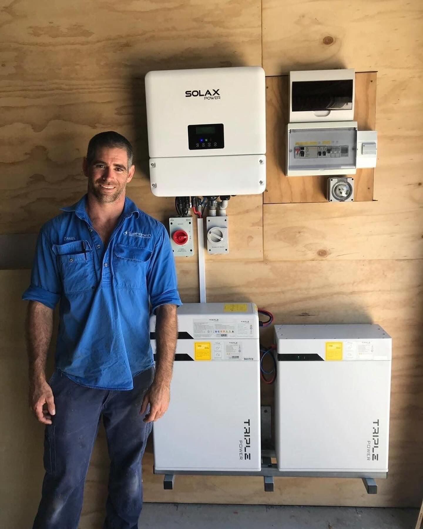 Man in Blue Shirt Stands by Solar Panel Equipment — Lahtinen Electrical & Refrigeration in Ingham, QLD