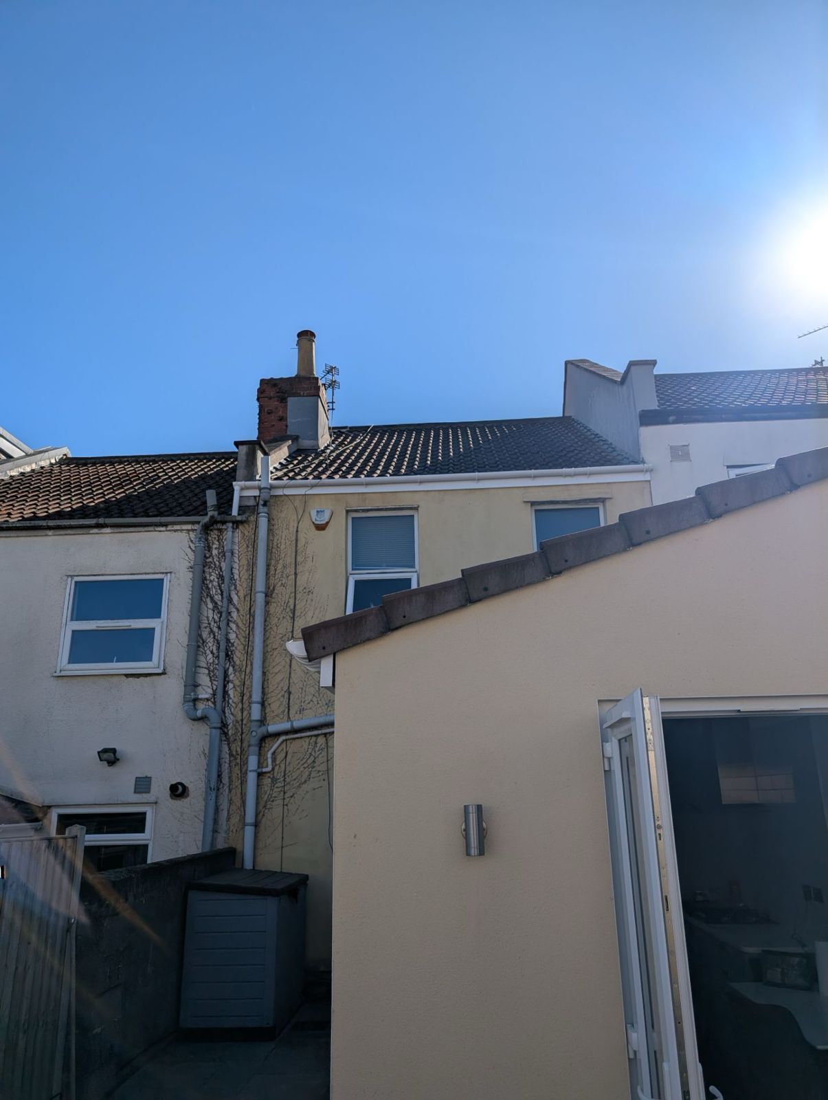 Sunny view of white houses with tiled roofs and a bright blue sky