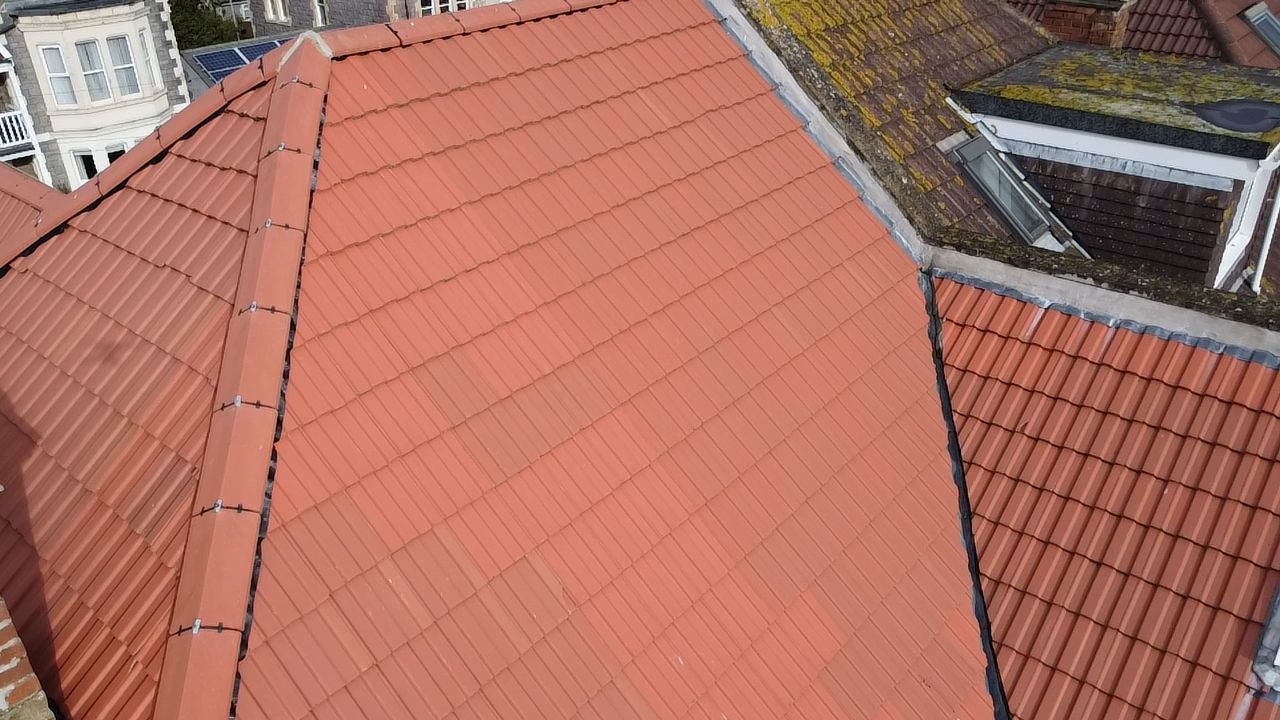 Red tiled rooftops of adjacent buildings, viewed from above.