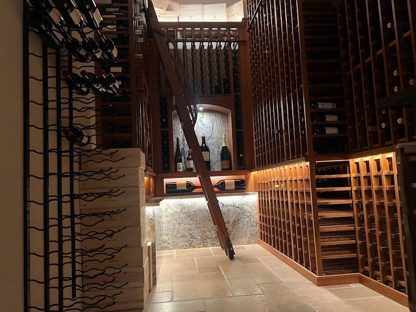 A wine cellar with a wooden ladder leading up to the second floor.