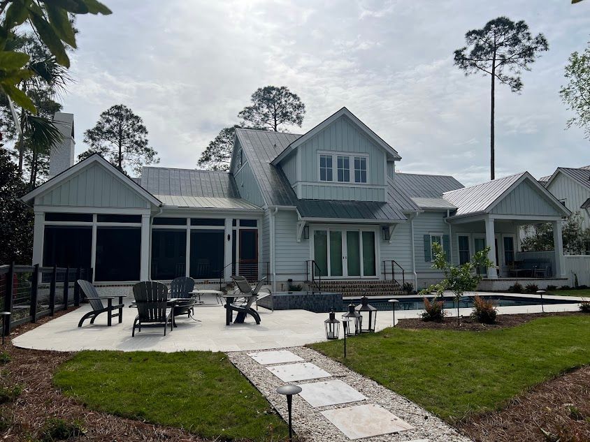A white house with a screened in porch and a pool