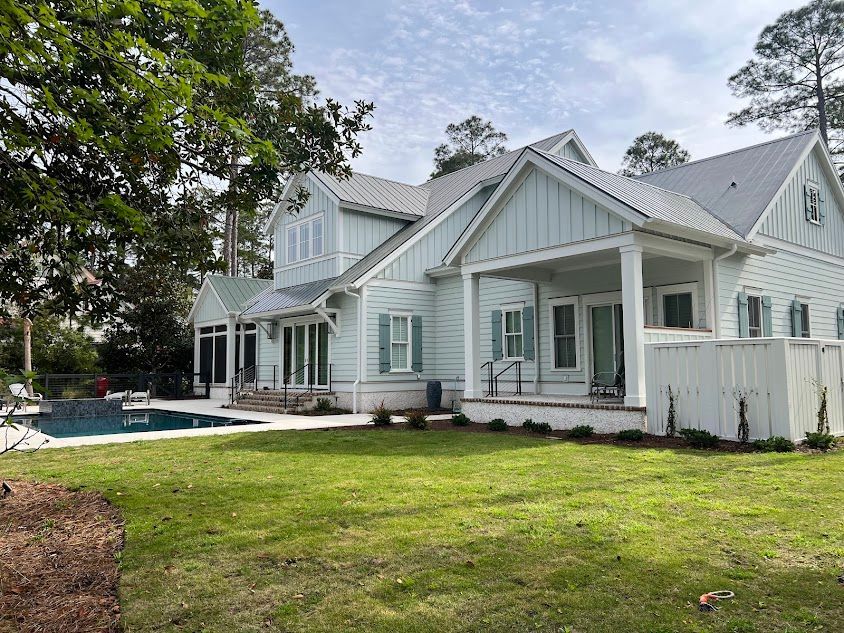 A large white house with a swimming pool in the backyard.