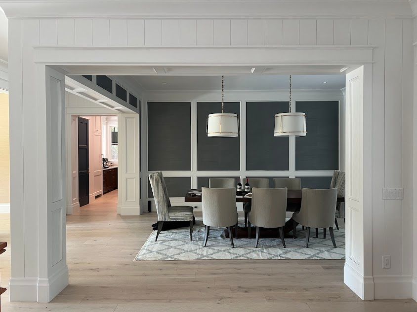 A dining room with a table and chairs and a rug.