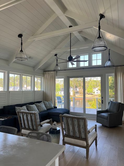 A living room with a couch , chairs , and a ceiling fan.