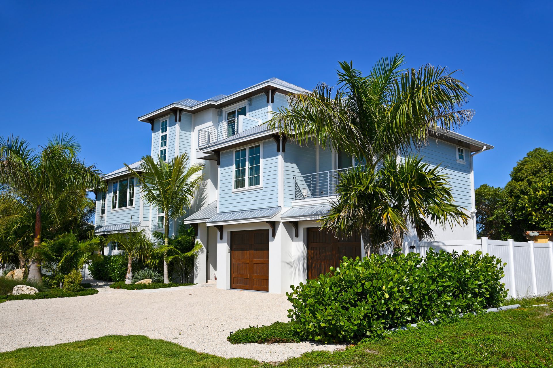 A large white house with palm trees in front of it