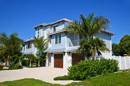A large white house with palm trees in front of it