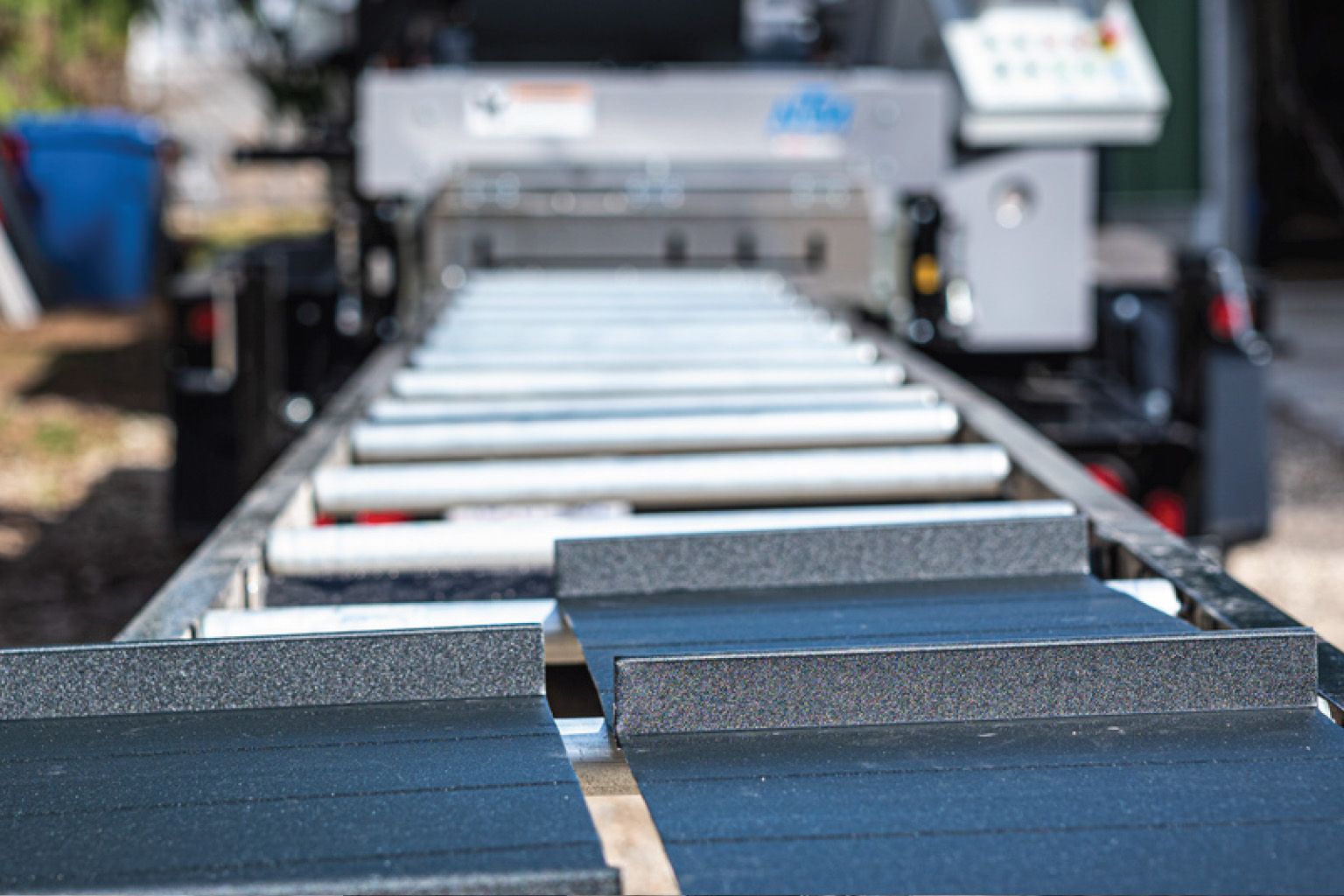 A person in blue gloves soldering copper guttering outdoors.