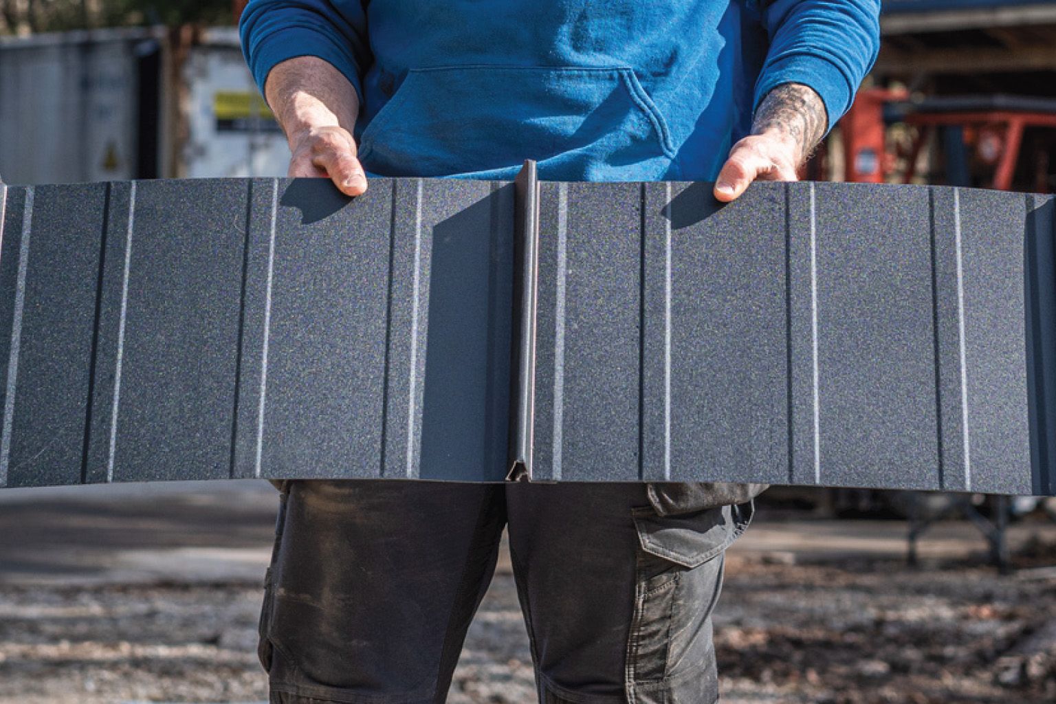 Brown wood siding on a modern building with black-framed windows and a gray roof.