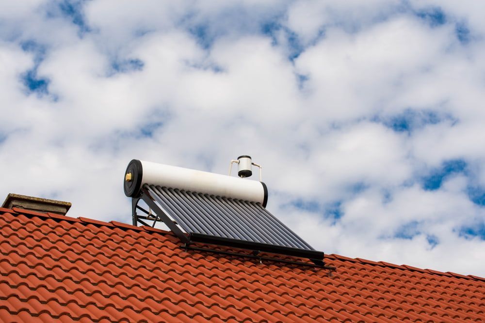 A Solar Water Heater is Mounted on the Roof of a House — Beaumont Plumbing in Glenfield Park, NSW