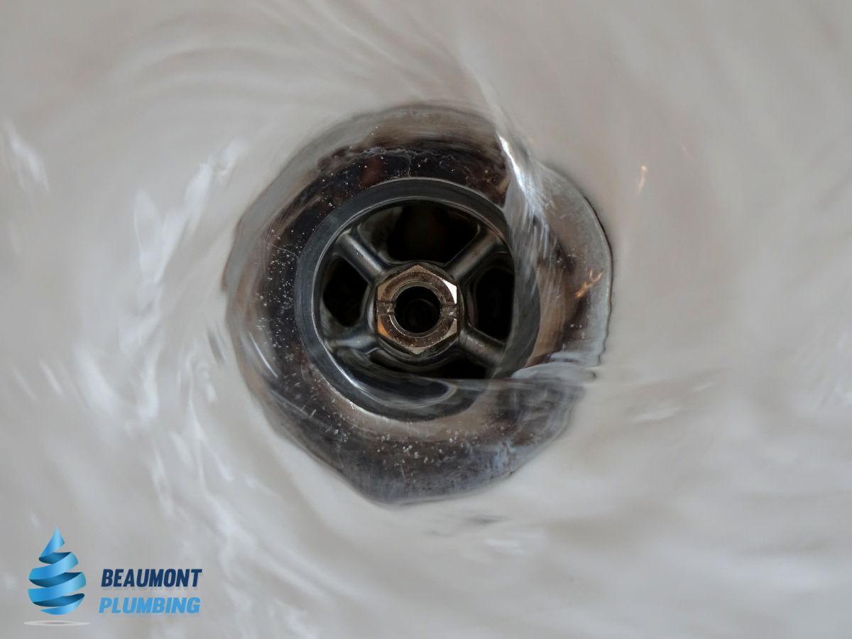 A Close Up of a Sink Drain With Water Coming Out of It — Beaumont Plumbing in Glenfield Park, NSW