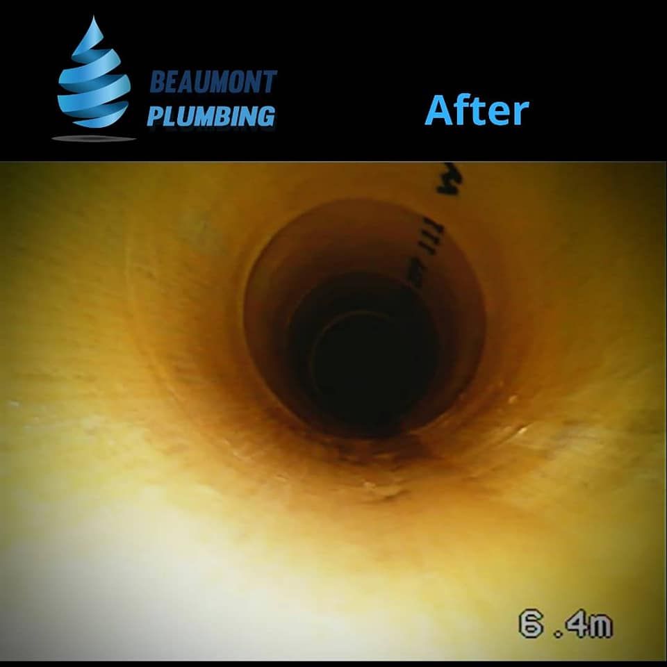 A Picture of a Hole in a Pipe That Says Beaumont Plumbing — Beaumont Plumbing in Glenfield Park, NSW