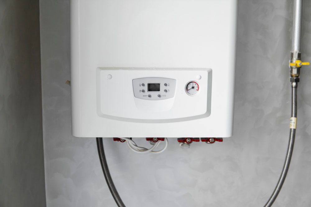 A White Boiler is Hanging on a Wall — Beaumont Plumbing in Glenfield Park, NSW