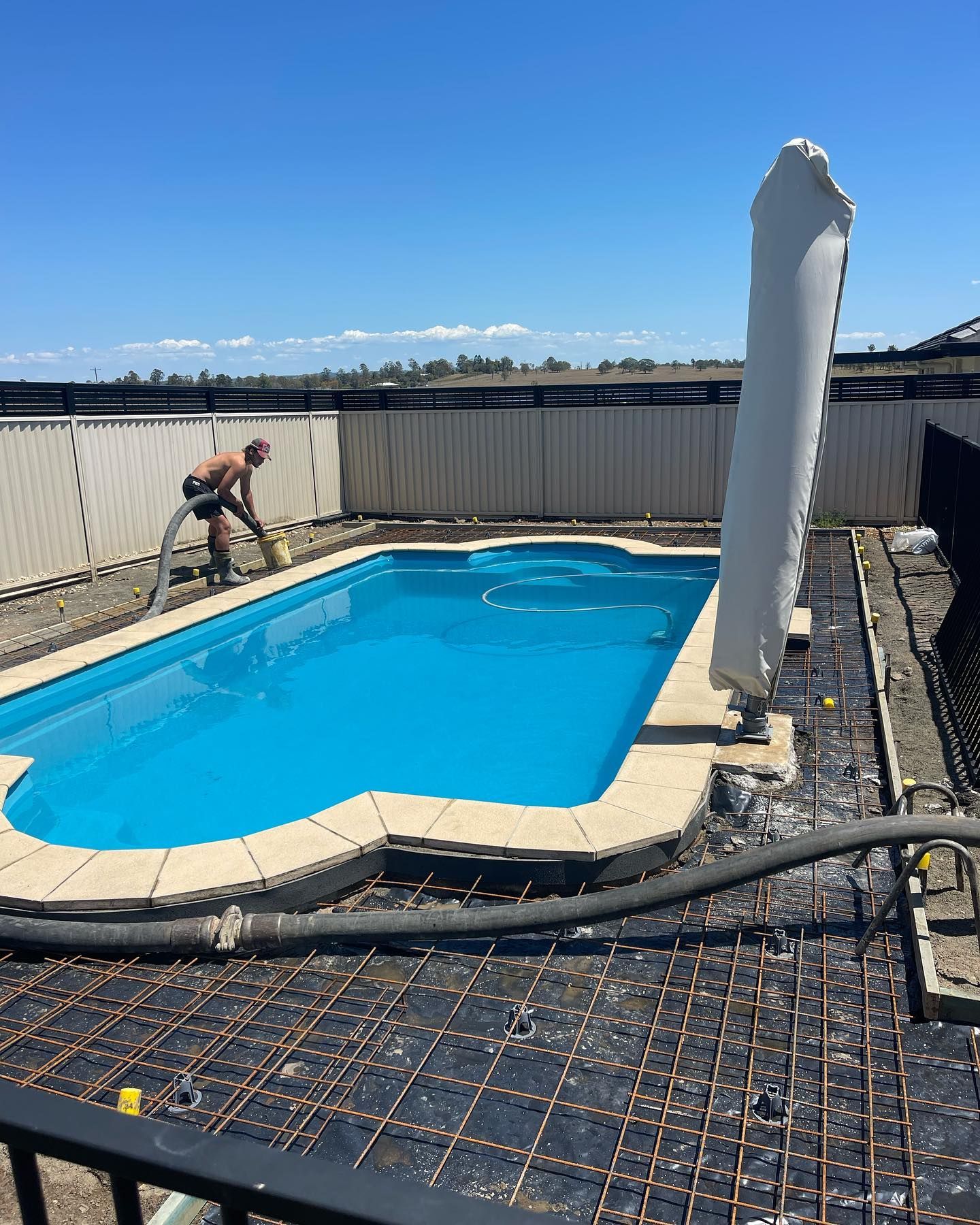 A Man is Pumping Water into a Swimming Pool — Casino, NSW — Lismore Concrete Pumping