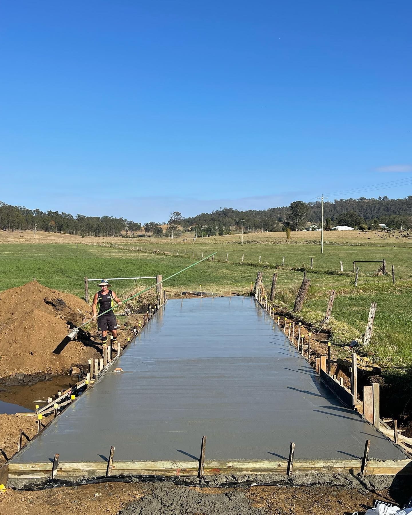 Man Standing on a Concrete Slab in a Field — Casino, NSW — Lismore Concrete Pumping