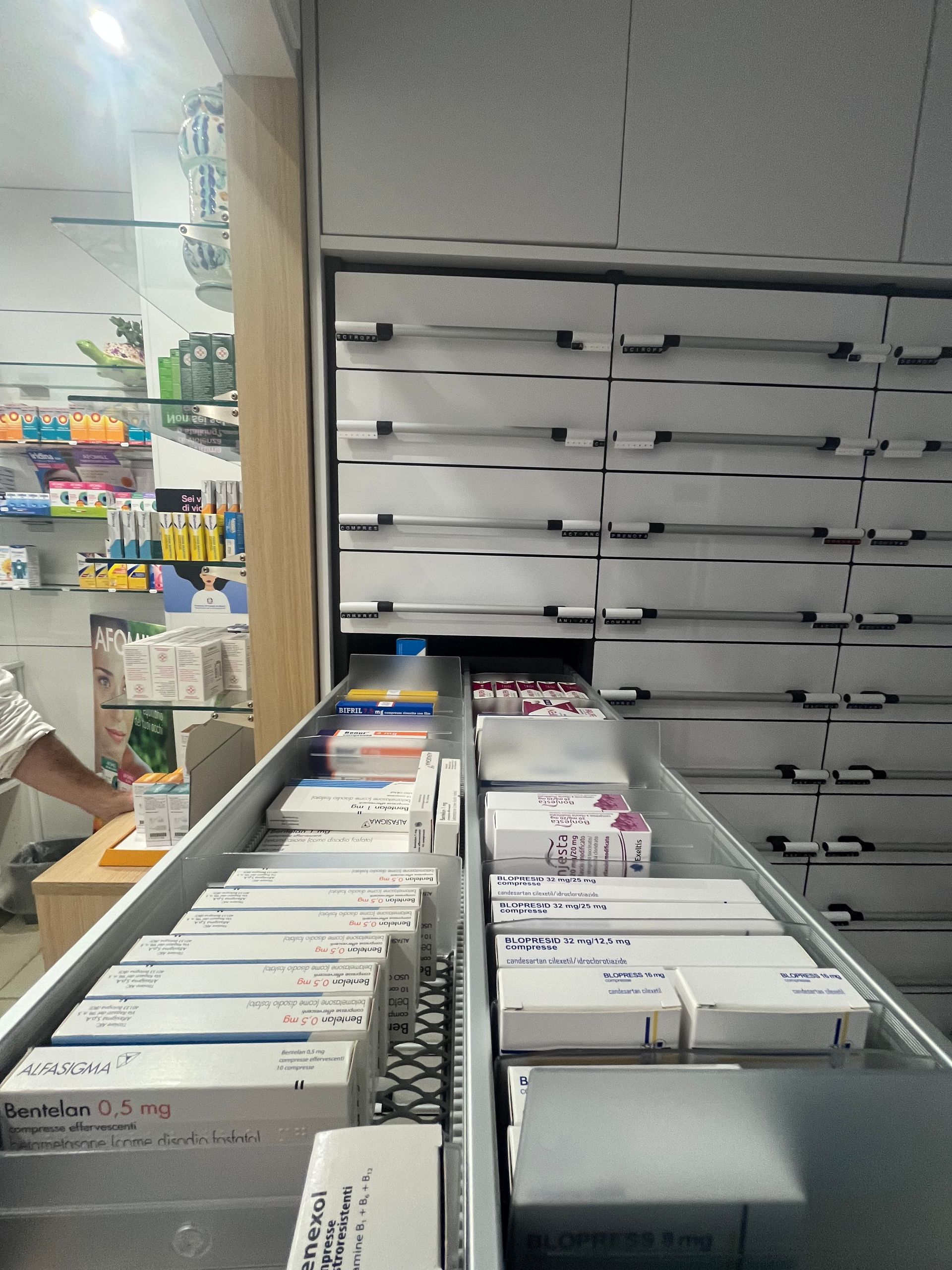 Una fila di cassetti in una farmacia pieni di scatole di medicinali