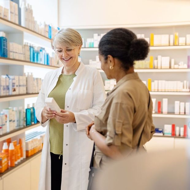 Una farmacista parla con un cliente in farmacia.