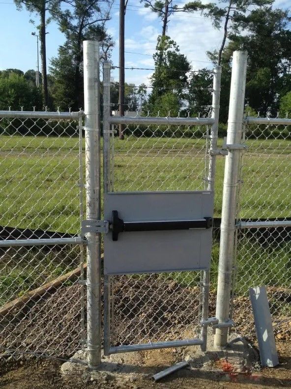 A chain link fence with a gate that is open