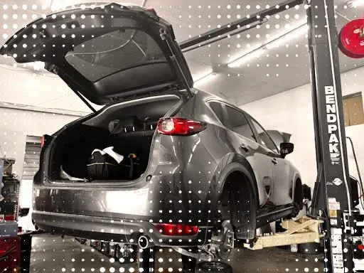 White Light-Duty Diesel Truck Raised in Garage | Compass Mechanical Repair