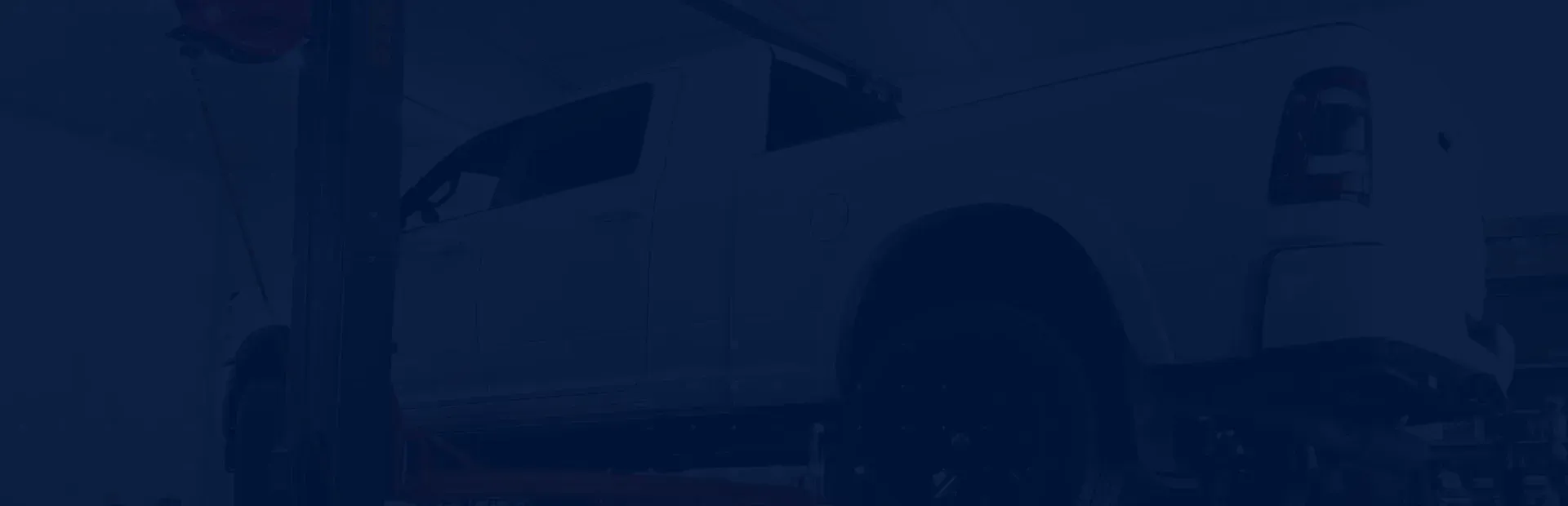 Truck in garage with blue background | Compass Mechanical Repair