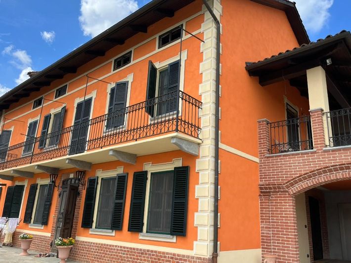 Un grande edificio arancione con persiane nere alle finestre