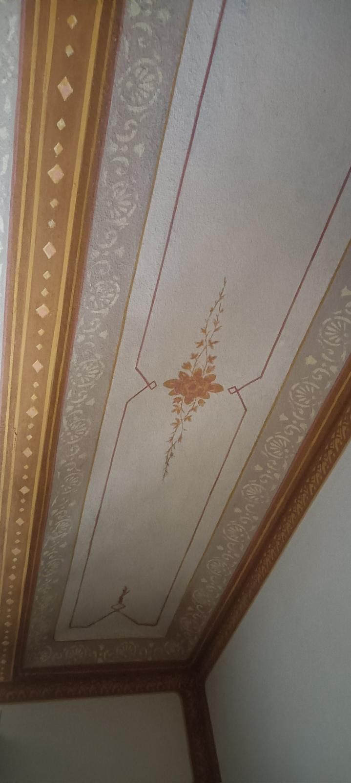 Un primo piano di un soffitto con un disegno floreale.