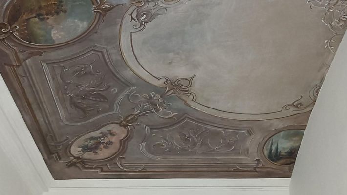 A close up of a ceiling with a painting on it.