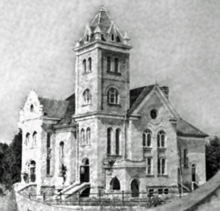 A black and white photo of a large building with a clock tower.