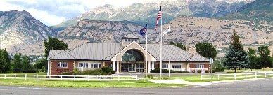 A building with mountains in the background and a flag in front of it