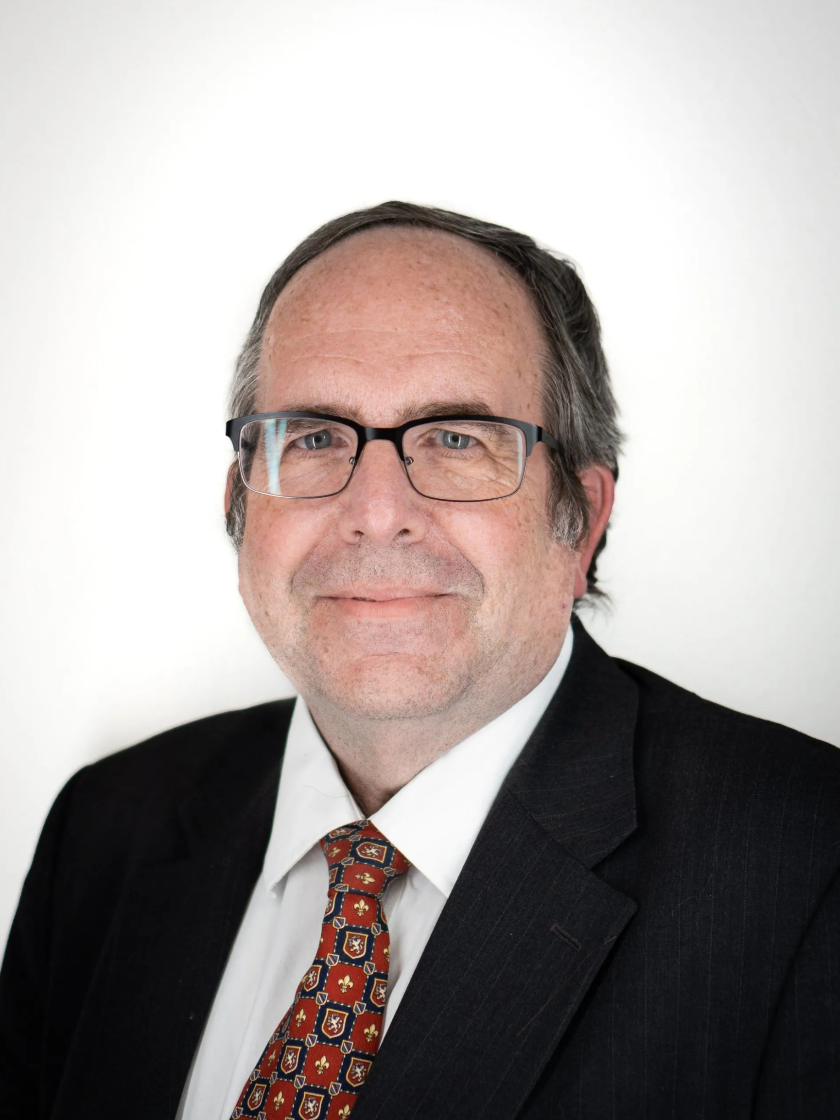 A man in a suit and tie is smiling for the camera.
