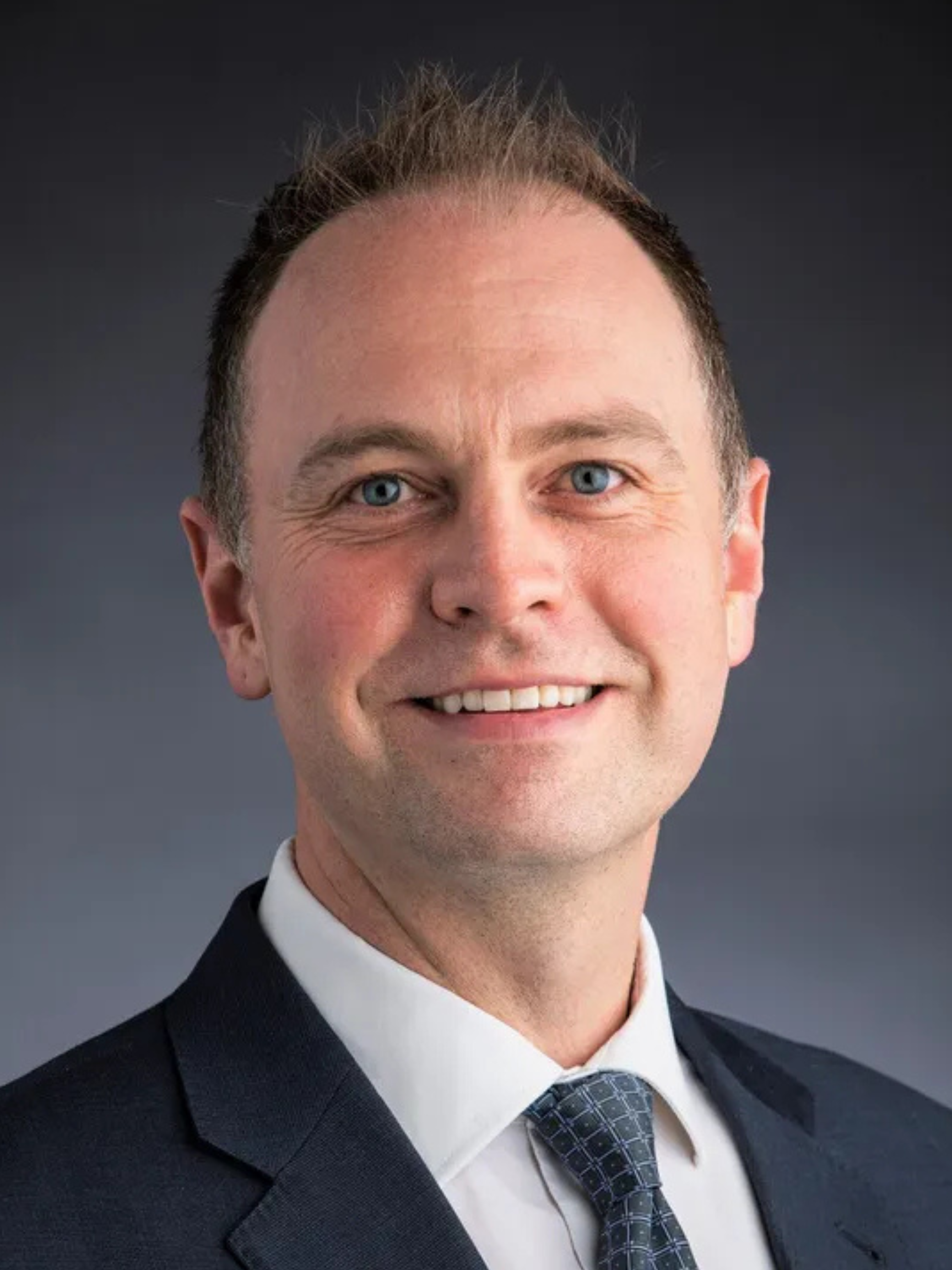 A man in a suit and tie is smiling for the camera.
