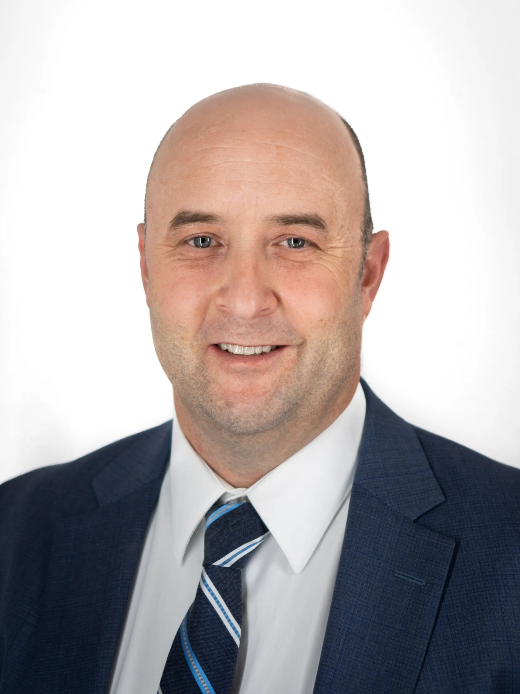 A man in a suit and tie is smiling for the camera.