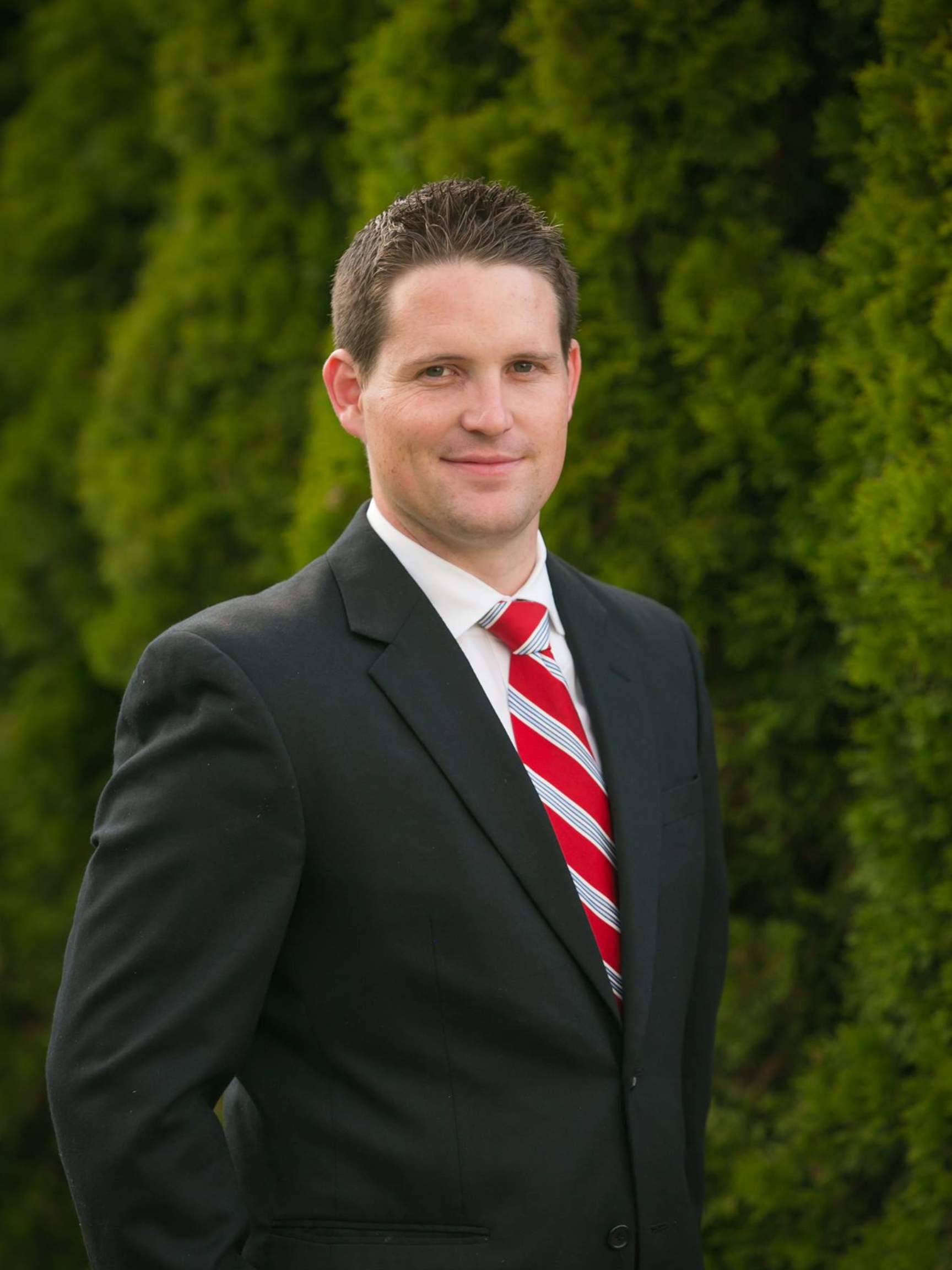 A man in a suit and tie is smiling for the camera.