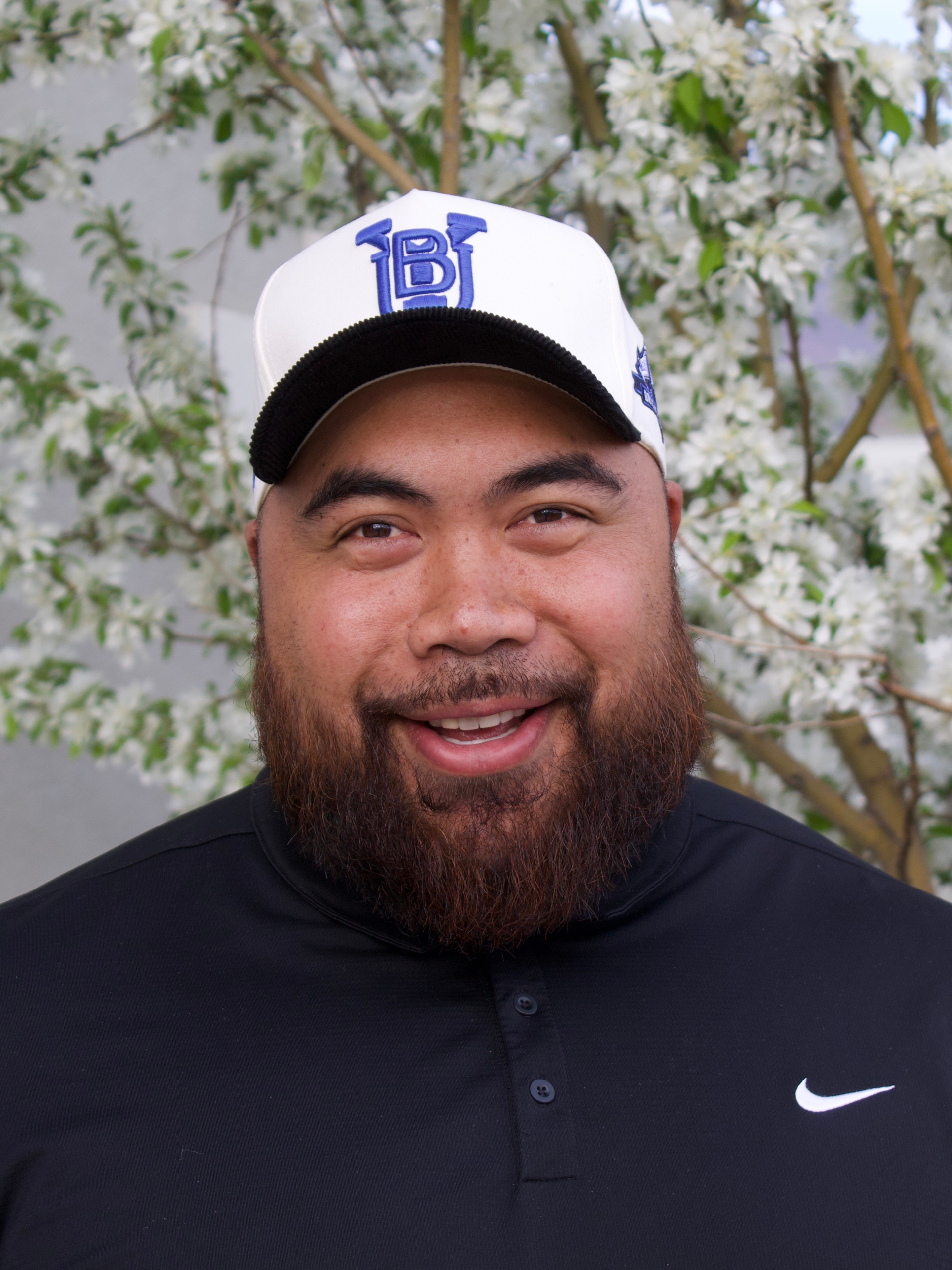 A woman in a black jacket is smiling for the camera