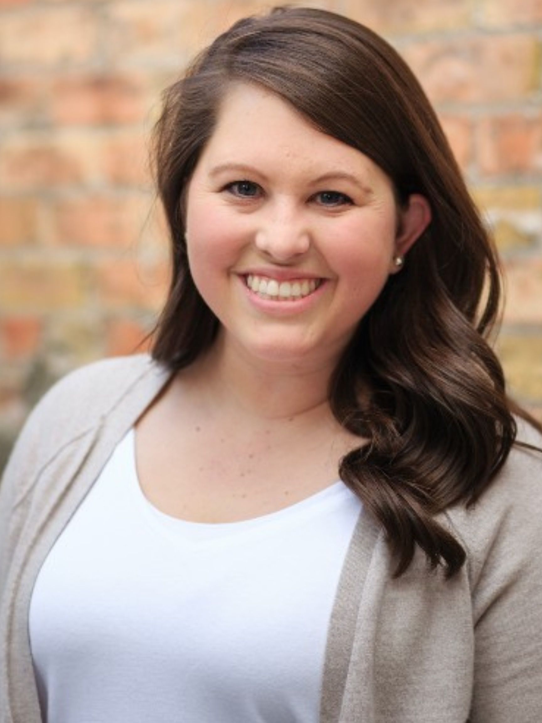 A woman with purple and blue hair is smiling for the camera.