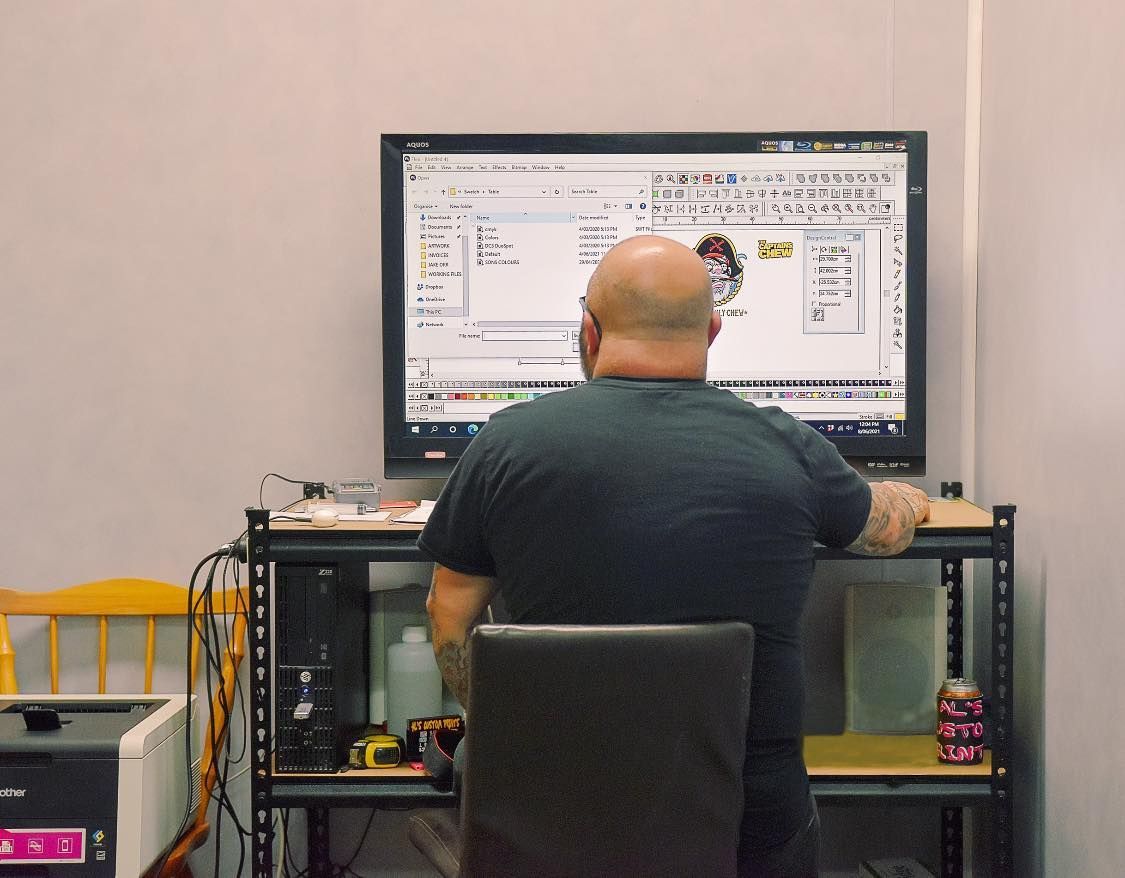 Person Seated at a Desk Working — Al's Custom Prints in Wyong, NSW