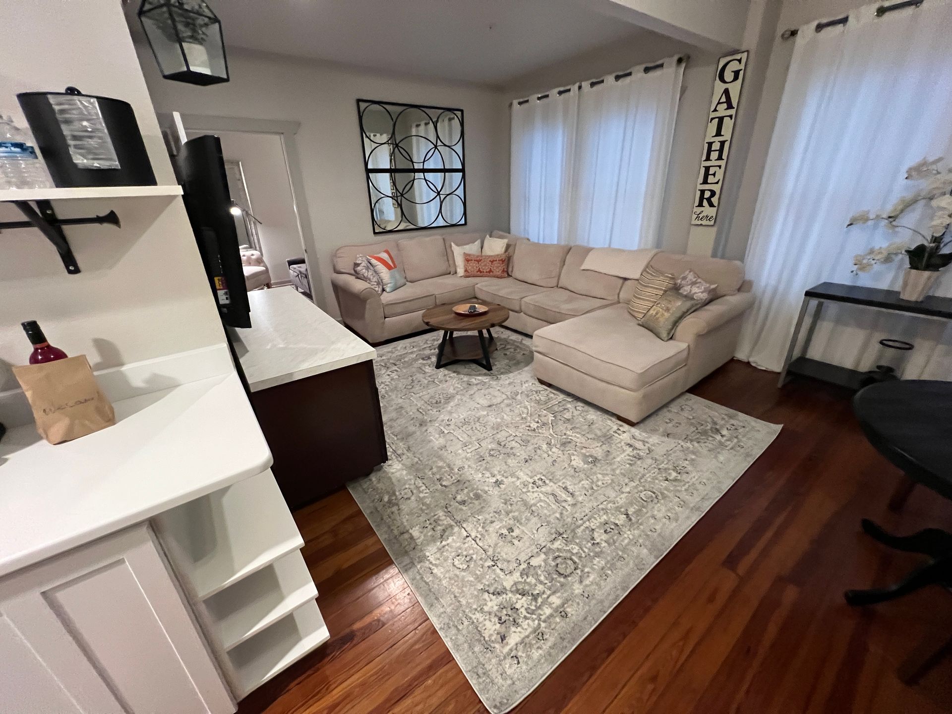 A living room with a sectional couch and a rug