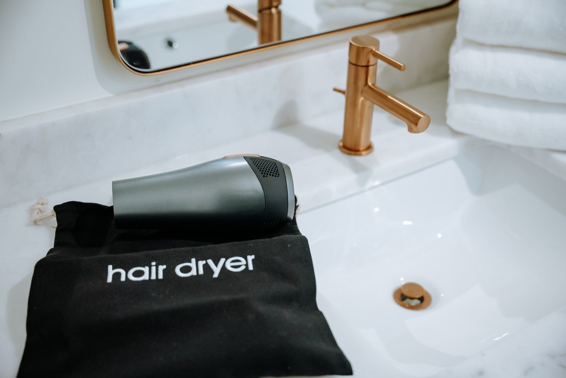 A hair dryer is sitting on top of a bathroom sink.