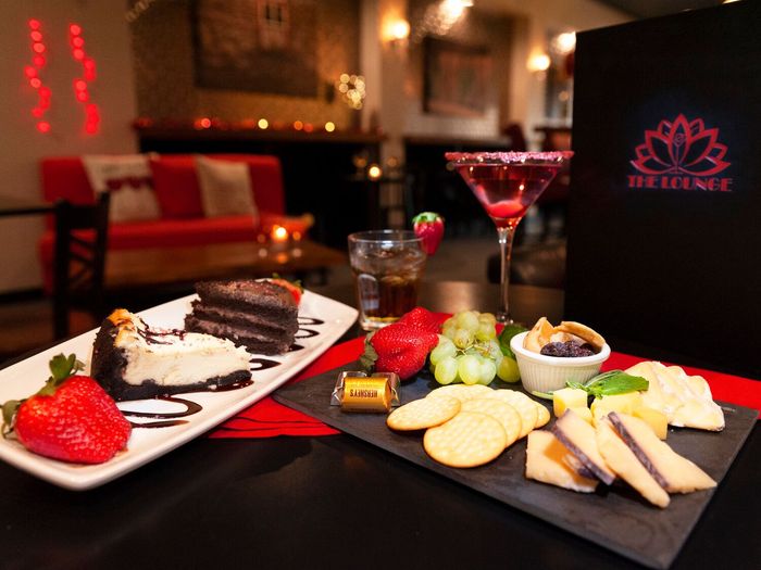 Two plates of food and a martini on a table at the lounge