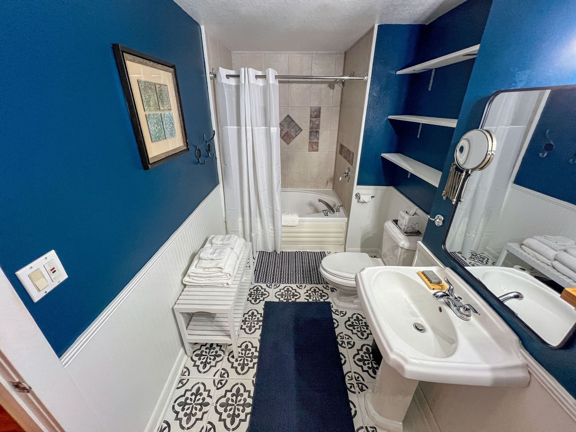 A bathroom with a sink , toilet , tub and mirror