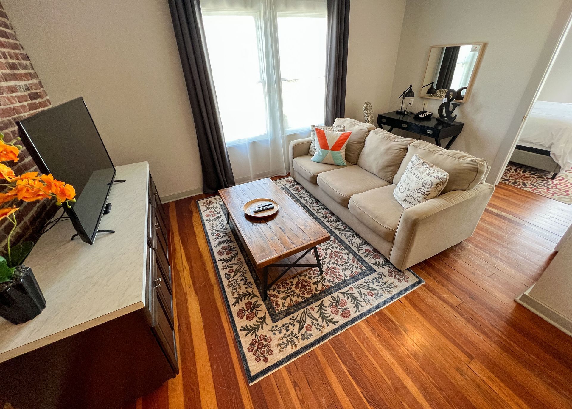 A living room with a couch , coffee table , and television.