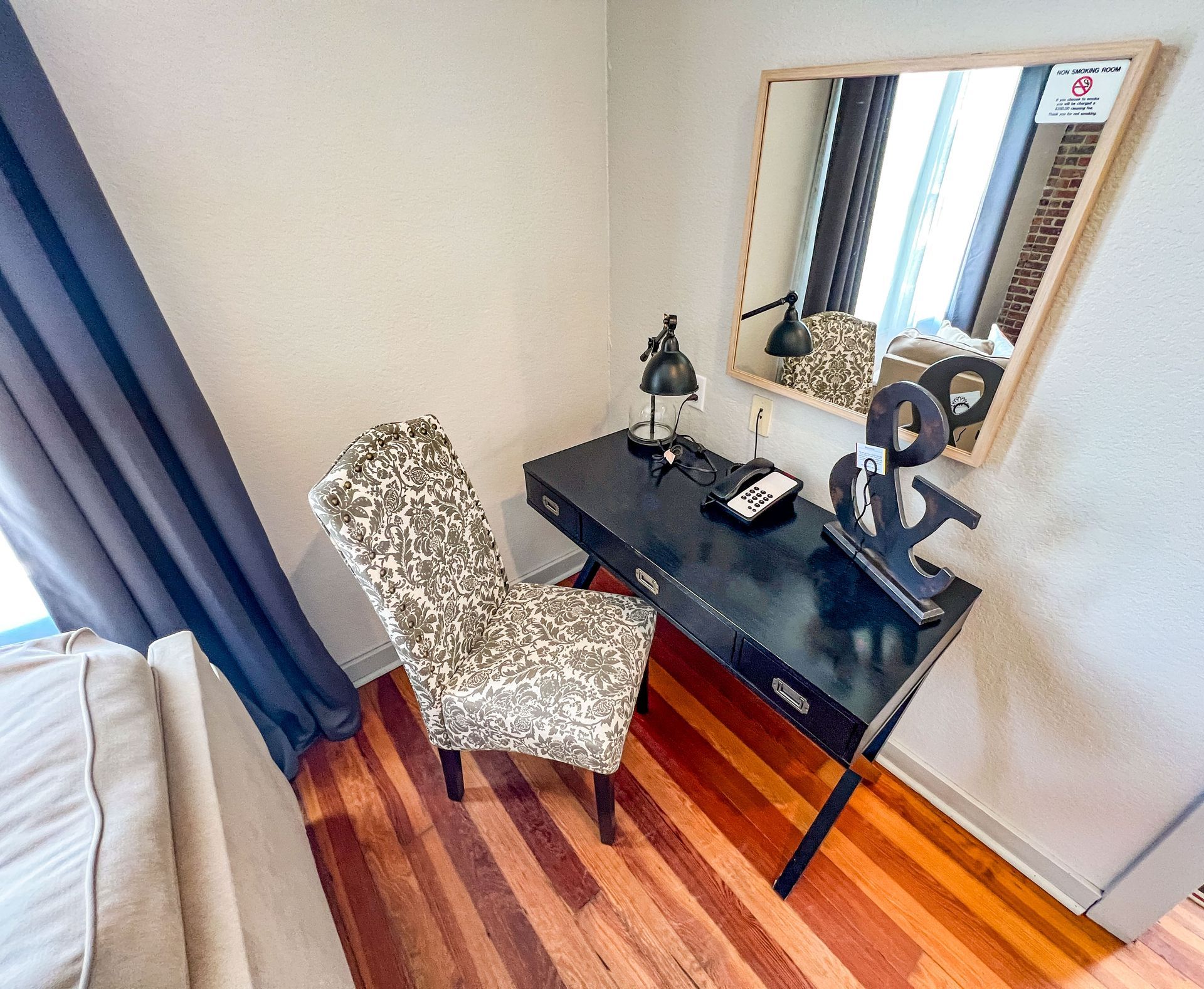 A room with a desk and chair and a mirror