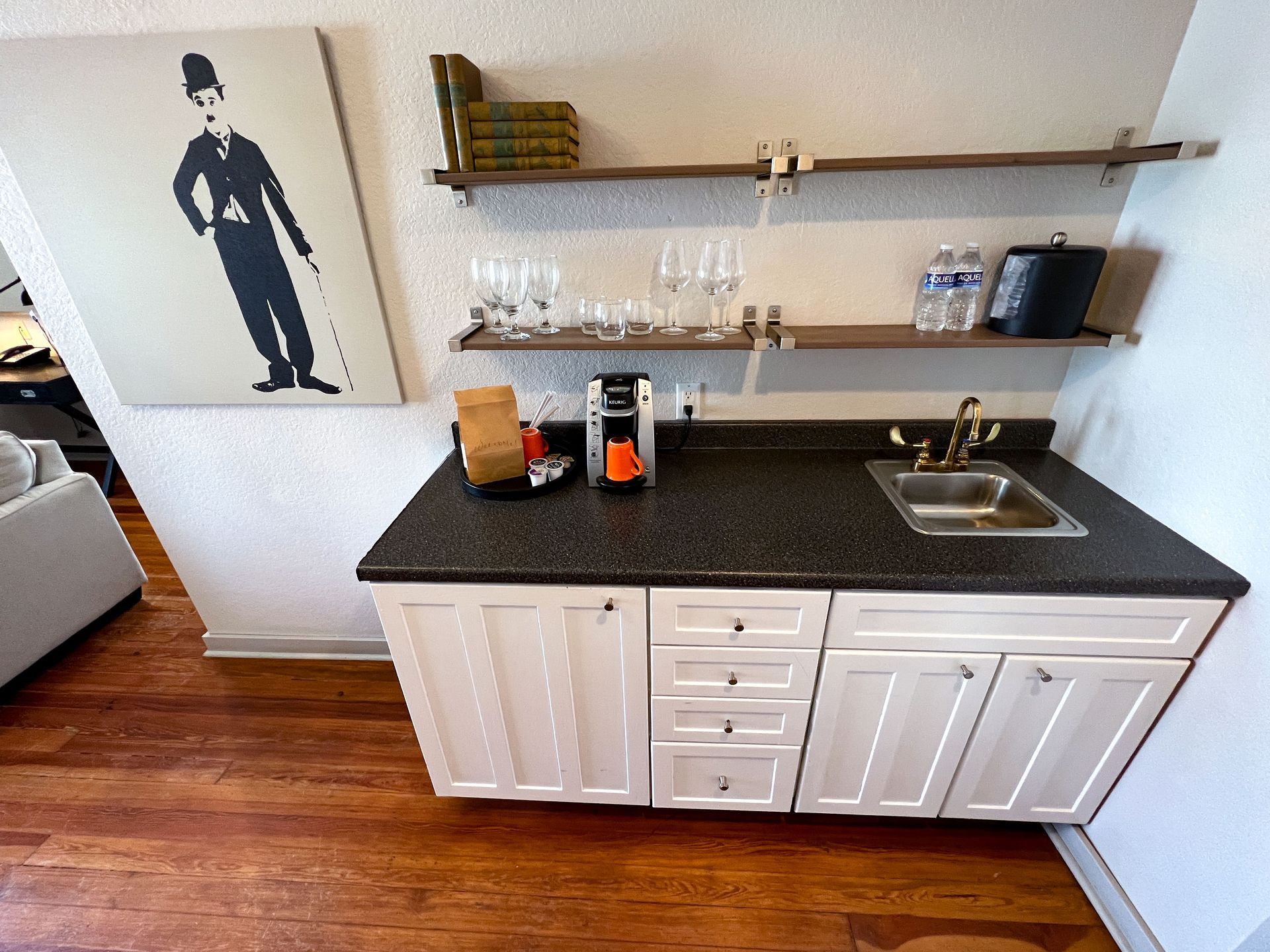 A kitchen with a picture of charlie chaplin on the wall above the sink