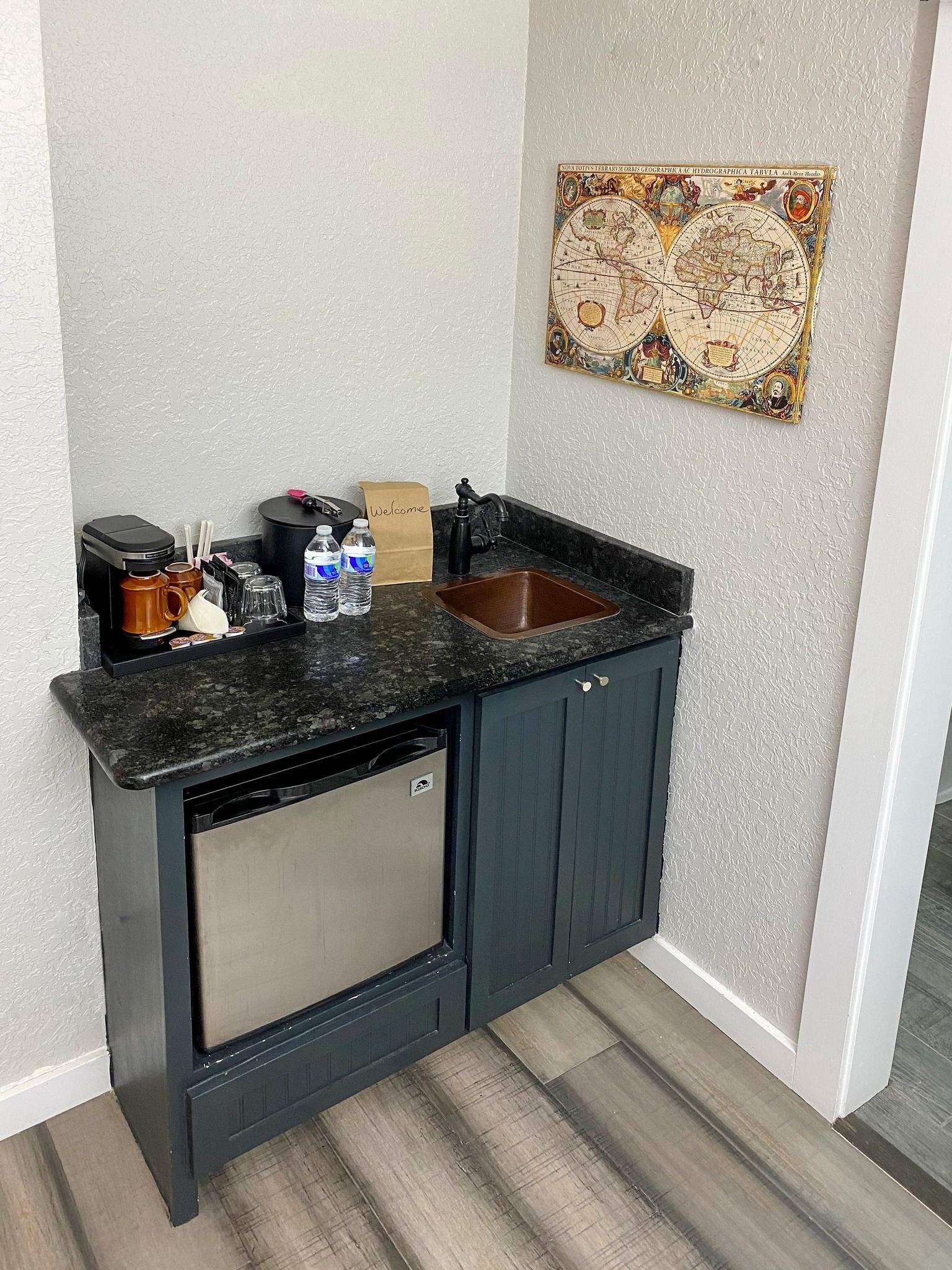 A small kitchen with a sink , refrigerator , and coffee maker.